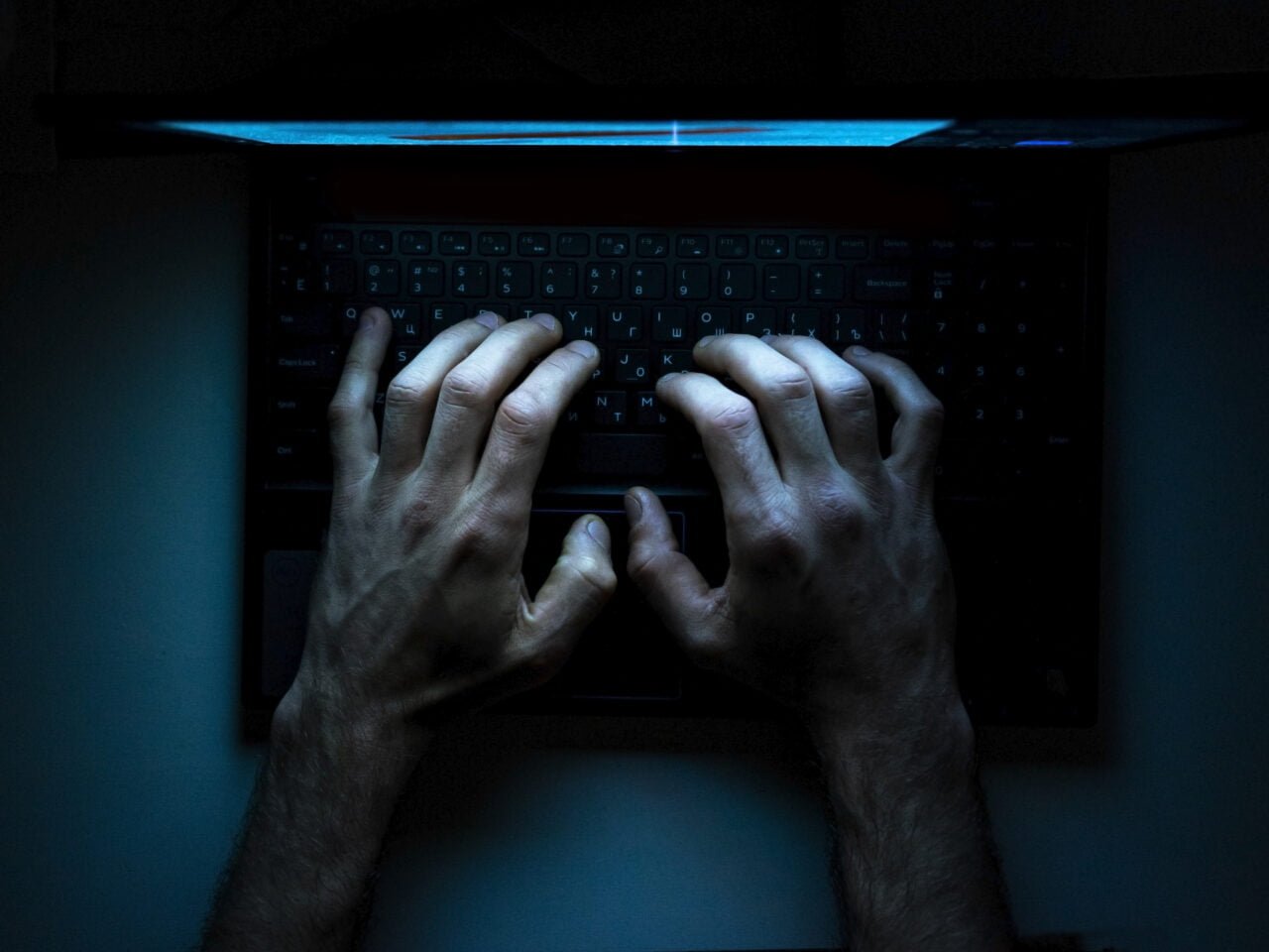 Top view of the hands of a programmer on  his laptop.